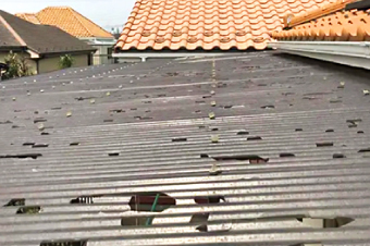 降雹による被害で多数の穴が空いた施工前のベランダポリカ波板の屋根